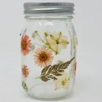 Glass mason jar decorated with pressed flowers