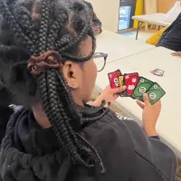teen with Uno card hand
