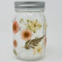 Glass mason jar decorated with pressed flowers